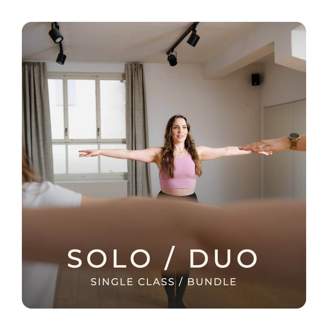 Laptop showing a live online private dance class with women stretching on the studio floor